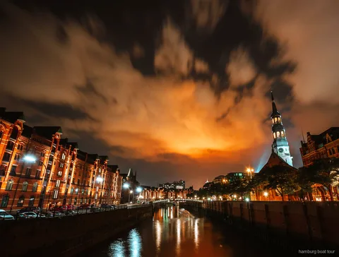 Barcassa tradicional sortint en un creuer nocturn de llums pel port de Hamburg