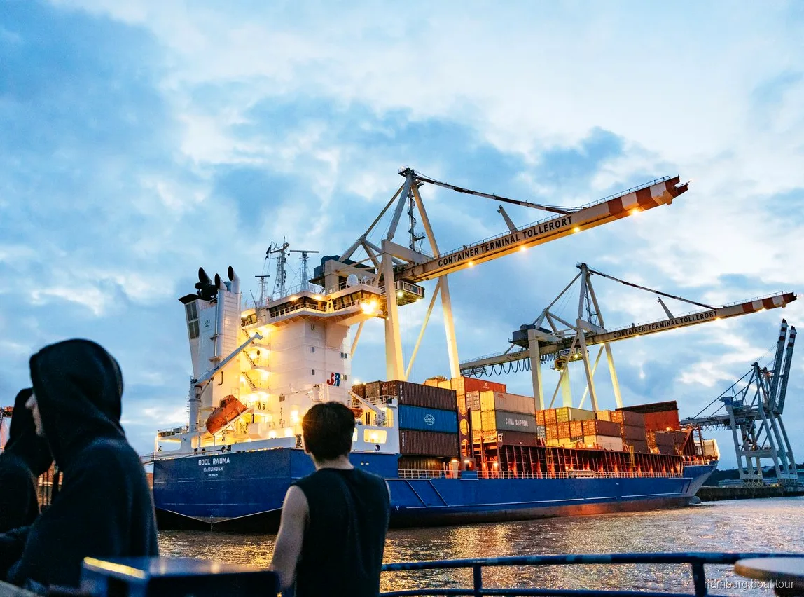Passagers détendus sur le pont pendant une croisière nocturne dans le port de Hambourg