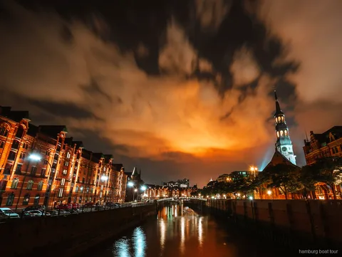 Traditional barge departing on a Hamburg evening lights harbor cruise