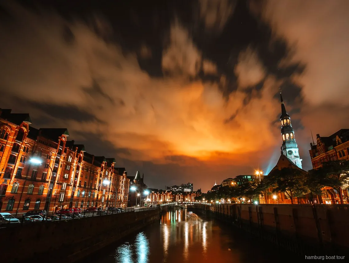 Traditional barge departing on a Hamburg evening lights harbor cruise