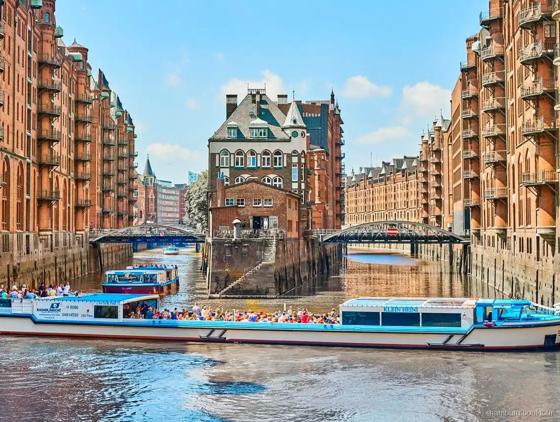 Passengers on the open deck of a Hamburg harbor and Speicherstadt cruise boat