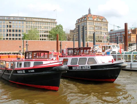 Båt som lämnar Binnenhafens ponton på en budgetvänlig hamnrundtur i Hamburg