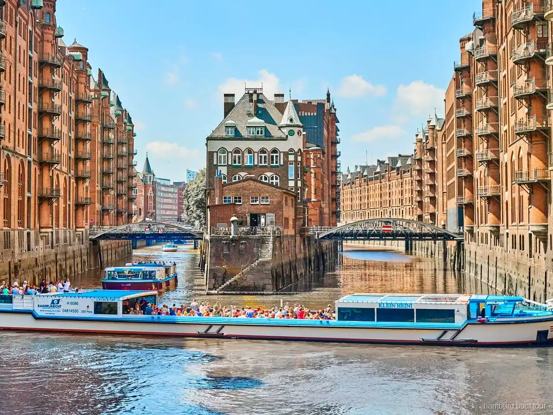 Passagerare på det öppna däcket av en hamnrundtur med Speicherstadt i Hamburg