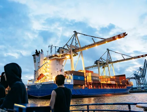 Passagiers ontspannen aan dek tijdens een avondvaart in Hamburg