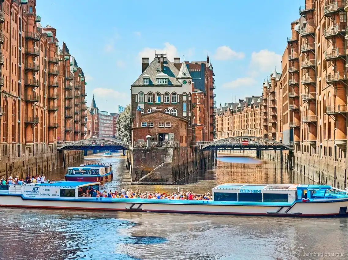 Passagiers op het open dek van een Barkasse tijdens een havenrondvaart Speicherstadt