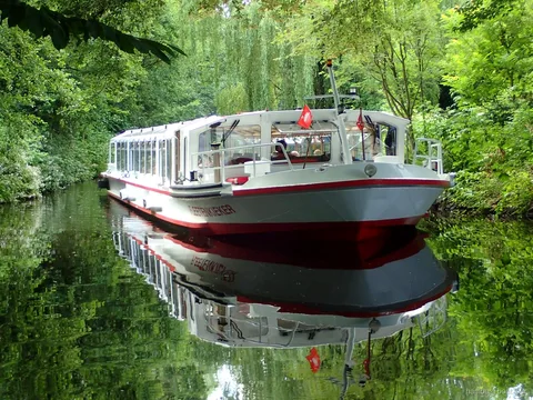 Gröna strandkanter och koloniträdgårdar på kanalturen på Alster i Hamburg