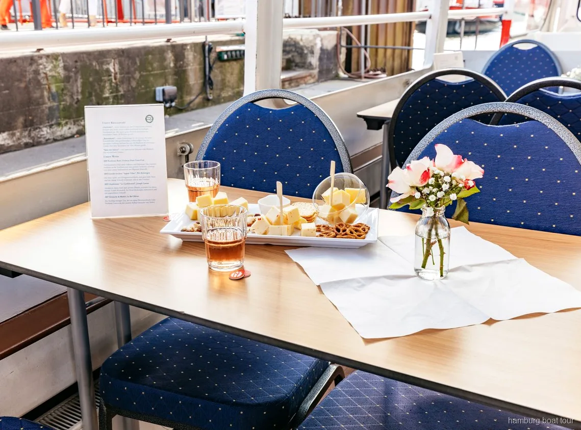 Solnedgångsvy över Hamburgs hamn från vin- och ostrundturens båt